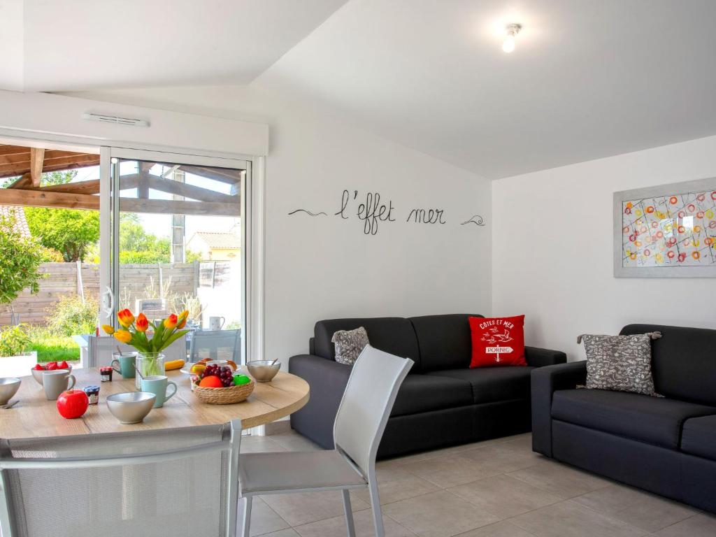 un salon avec une table et un canapé dans l'établissement Holiday Home L'Effet Mer by Interhome, à La Bernerie-en-Retz