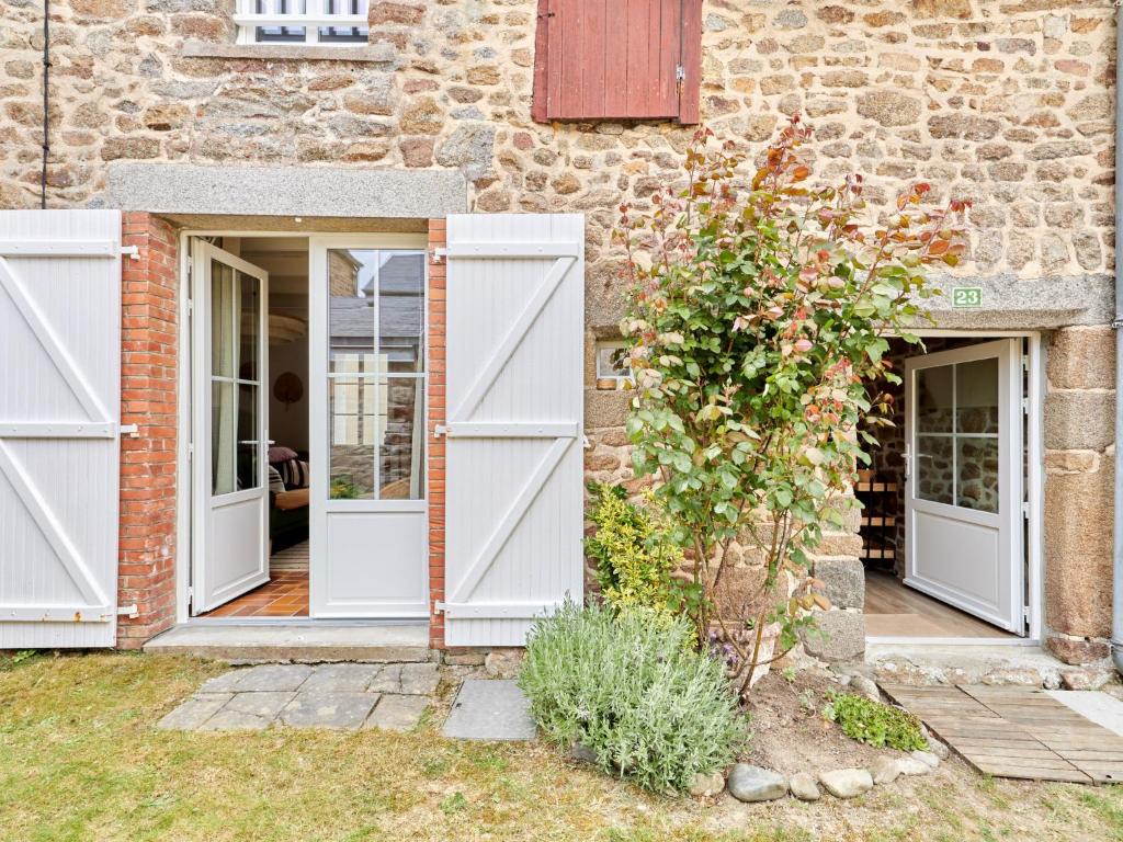 une maison avec des portes blanches et un mur en pierre dans l'établissement Holiday Home Cottage Carolles by Interhome, à Carolles