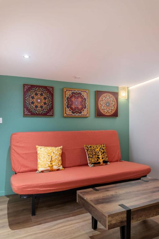 - un canapé rouge dans une pièce ornée de peintures murales dans l'établissement Le Guilin - Duplex quais de Saône - Vieux Lyon, à Lyon