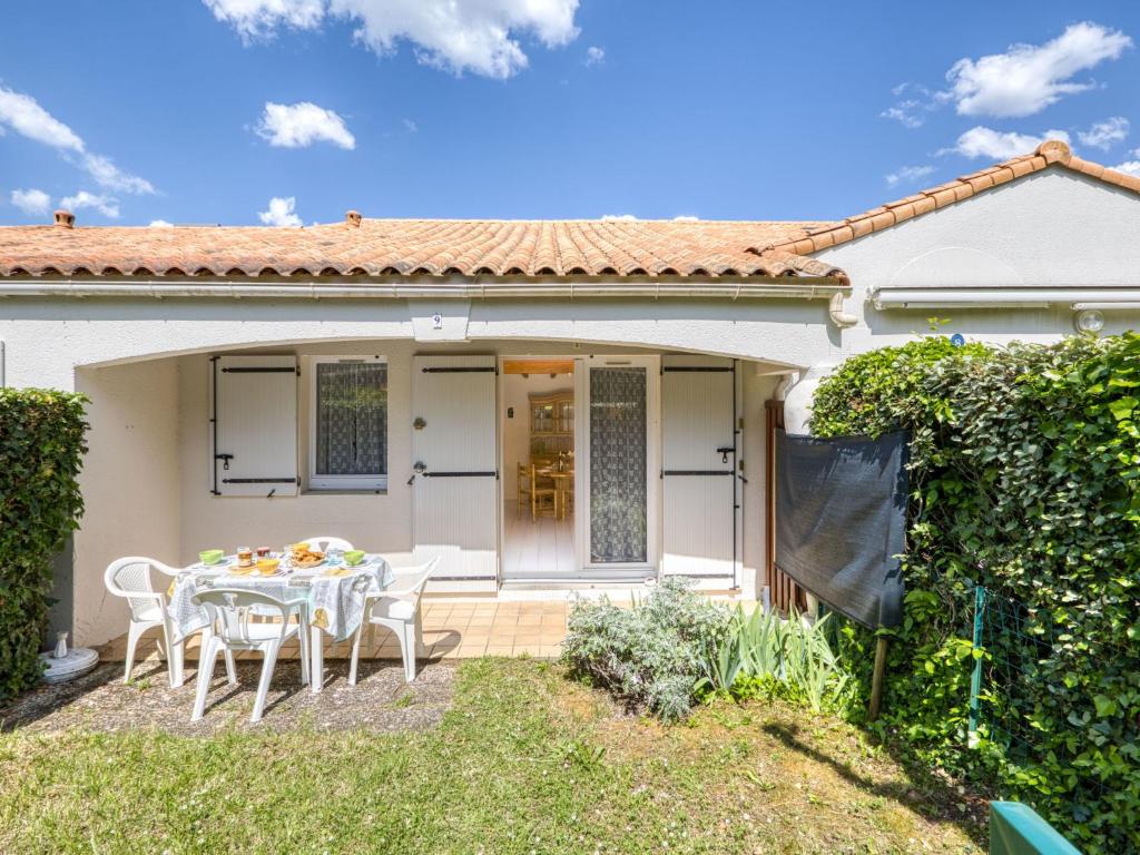 une maison blanche avec une table et des chaises dans l'établissement Apartment Maylis-2 by Interhome, à Saint-Palais-sur-Mer