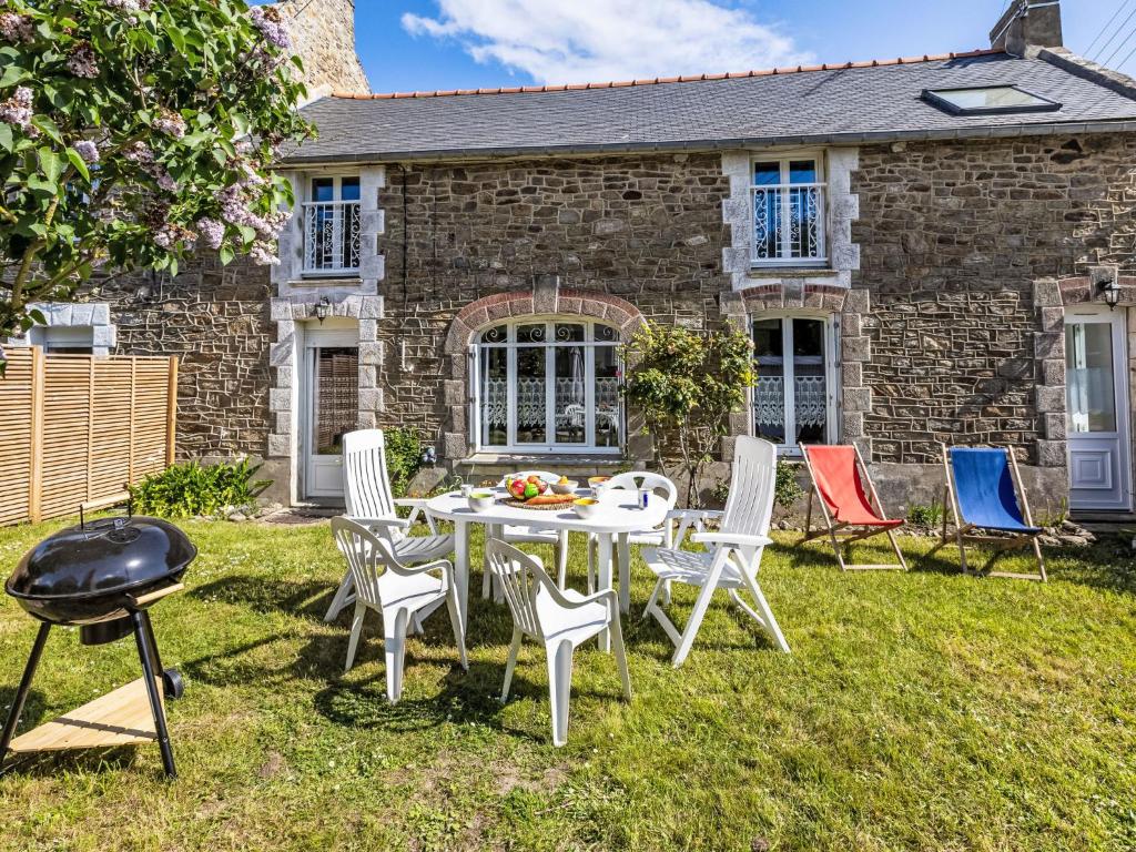 une table et des chaises devant une maison en briques dans l'établissement Holiday Home la Rivière by Interhome, à Cancale