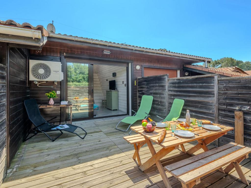une terrasse en bois avec une table et des chaises dessus dans l'établissement Apartment Les Malgaches-2 by Interhome, à Mimizan