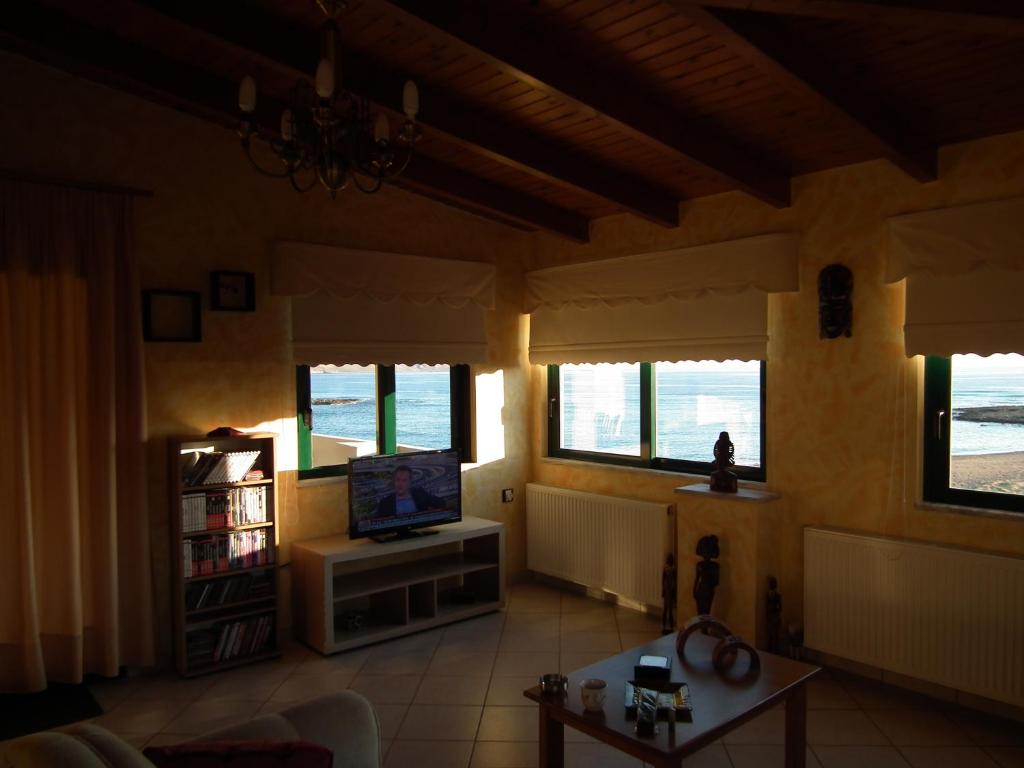 a living room with a tv and a couch and windows at Gramvoussa Bay in Kissamos