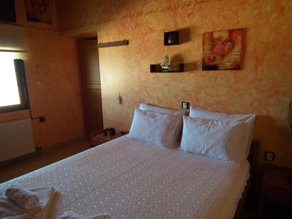 a bedroom with a bed with white sheets and pillows at Gramvoussa Bay in Kissamos