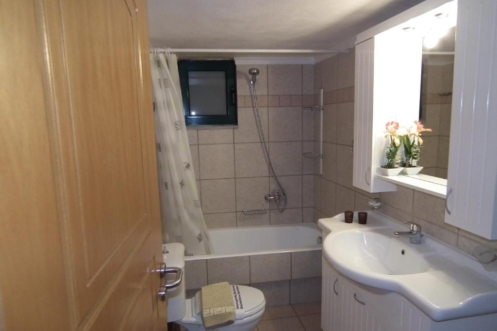 a bathroom with a sink and a toilet and a tub at Gramvoussa Bay in Kissamos