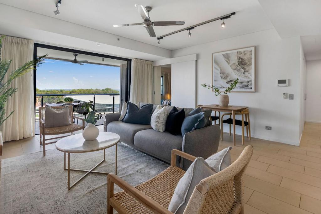 a living room with a couch and a table at Charming Waterfront Lagoon Views & Restaurants in Darwin