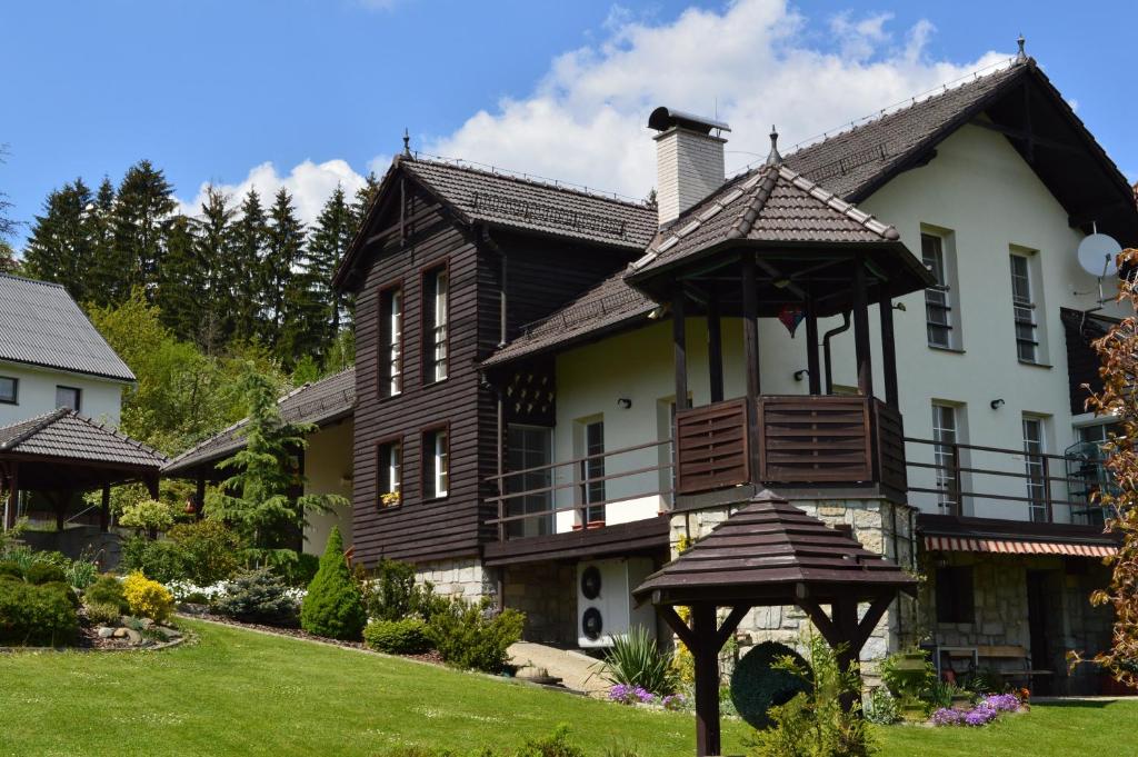 a large house with a balcony on the lawn at Privat Pod Skalkou in Velké Losiny