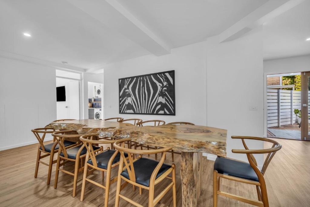 a dining room with a wooden table and chairs at Bellvilla - Bluebonnet Suite in Merimbula