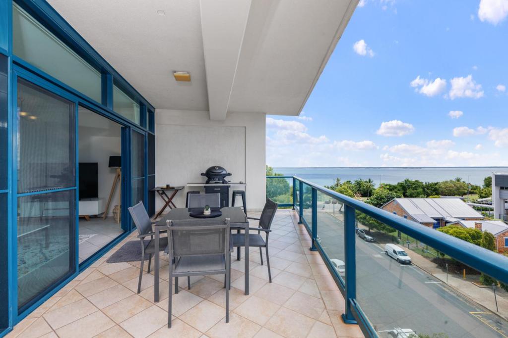 a house with a balcony with a table and chairs at Ideal CBD Location with Harbour Views Pool Gym & BBQ in Darwin