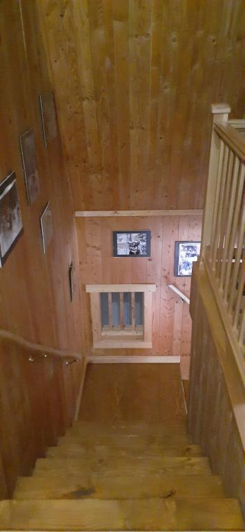 a room with a staircase in a wooden house at Grangette Entre Chiens et Loups in LʼAnse-Saint-Jean