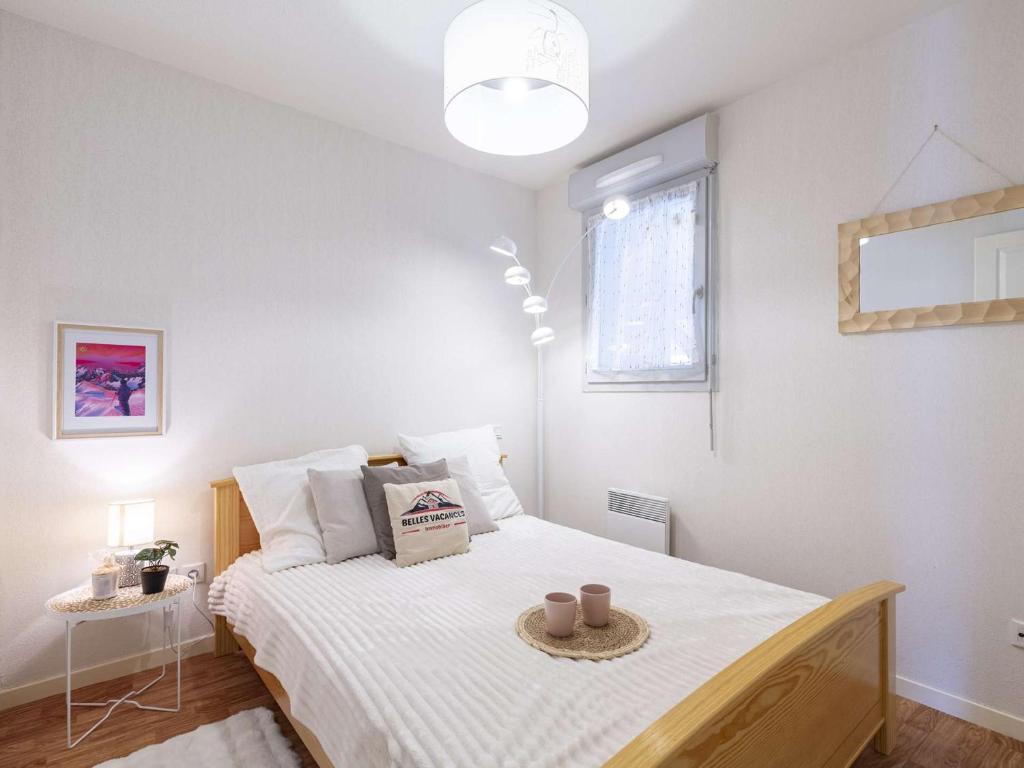 une chambre avec un lit avec des draps blancs et une fenêtre dans l'établissement Appartement rénové à Vielle-Aure, 4 pers, parking - FR-1-296-520, à Vielle-Aure