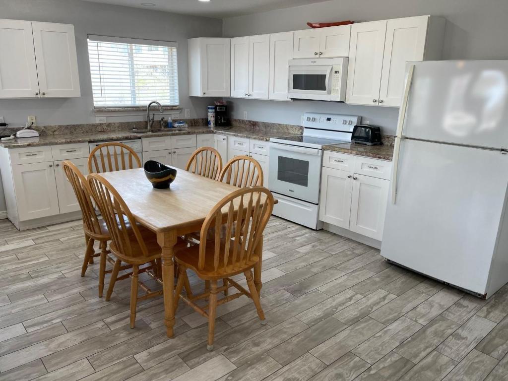 a kitchen with a table and chairs and a white refrigerator at Beachgate Condo Suites and Hotel 217 condo in Port Aransas