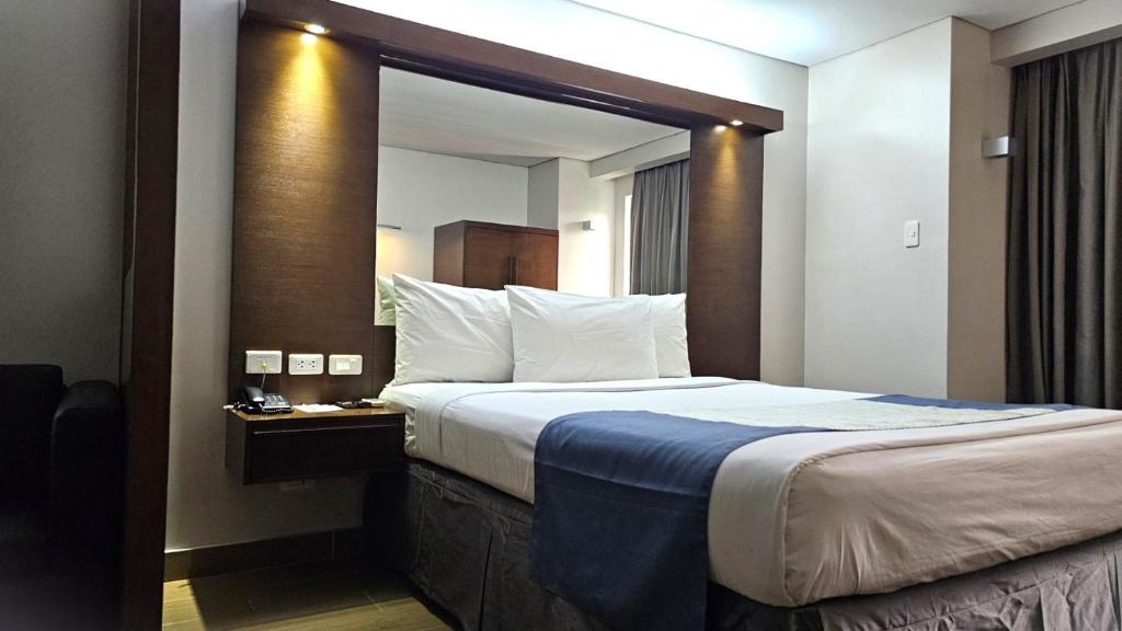 Postel nebo postele na pokoji v ubytování Microtel by Wyndham Acropolis
