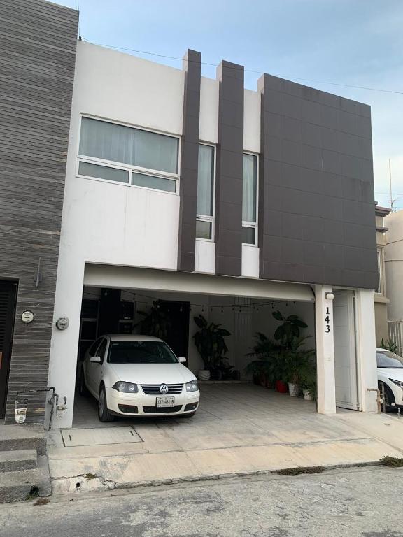 a white car parked in front of a garage at Un hogar lejos de Casa in Monterrey