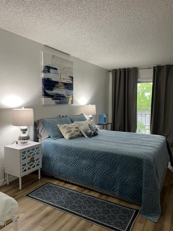 a bedroom with a blue bed and a window at Marazul in Cape Coral