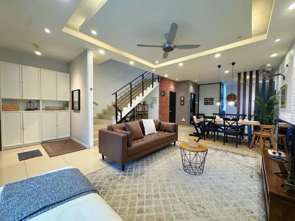 a living room with a couch and a dining room at Bangi Avenue Charming 4BR Blissful Holiday Homestay in Kajang