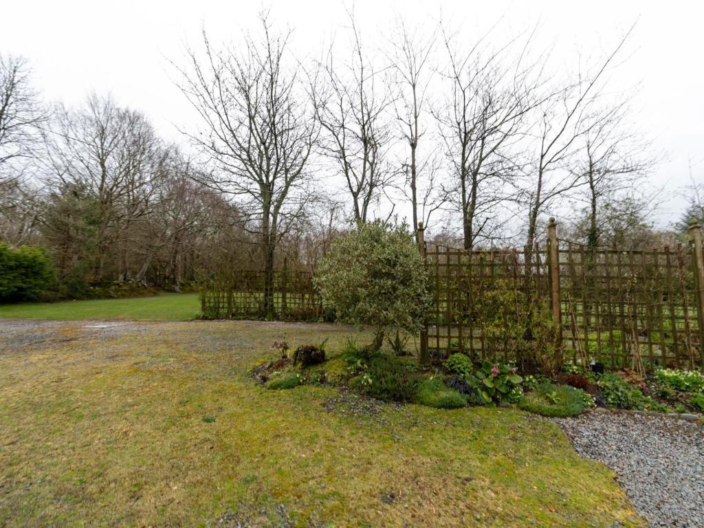 a wooden fence in a yard with a garden at Secluded Holiday Home in Ceredigion with Garden in Pennant