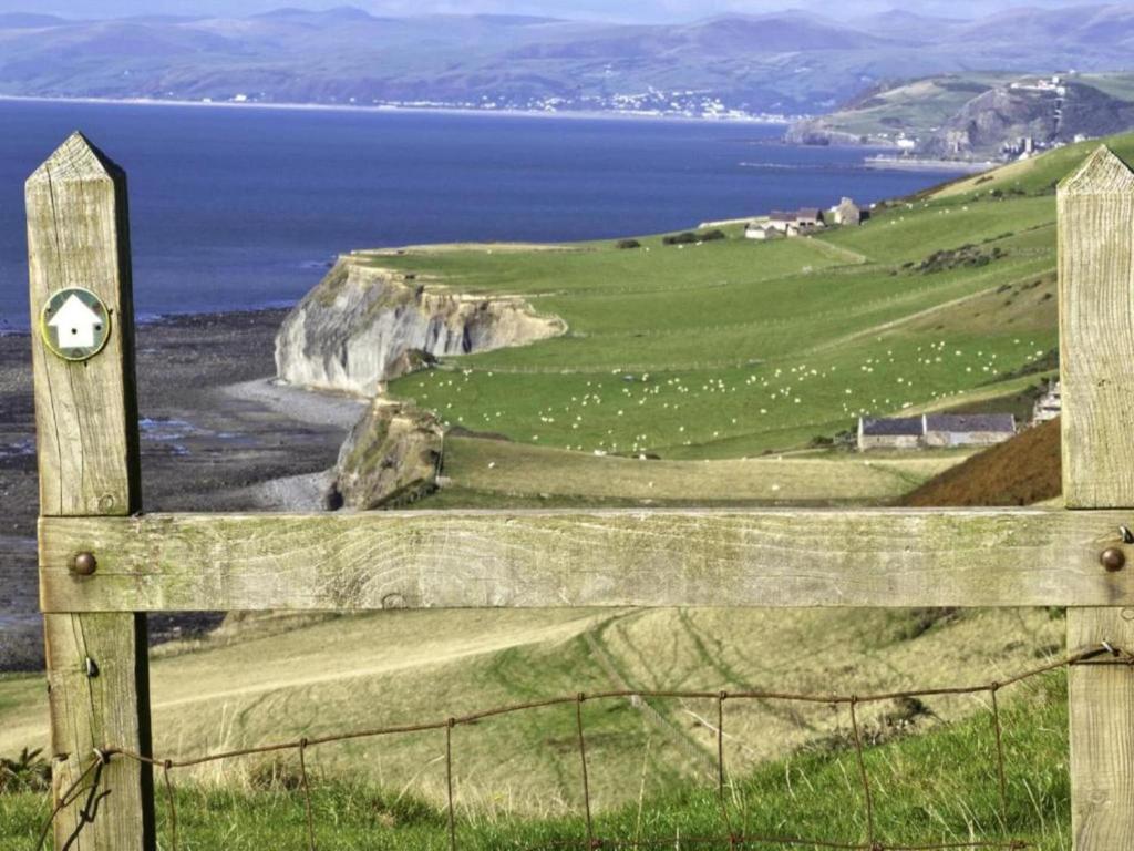 a wooden fence with a view of the ocean at Secluded Holiday Home in Ceredigion with Garden in Pennant