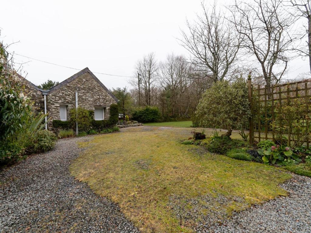 a house with a gravel driveway in front of a yard at Secluded Holiday Home in Ceredigion with Garden in Pennant