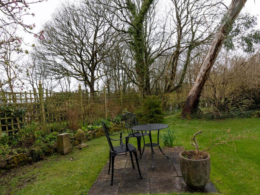 a table and two chairs in a garden at Secluded Holiday Home in Ceredigion with Garden in Pennant