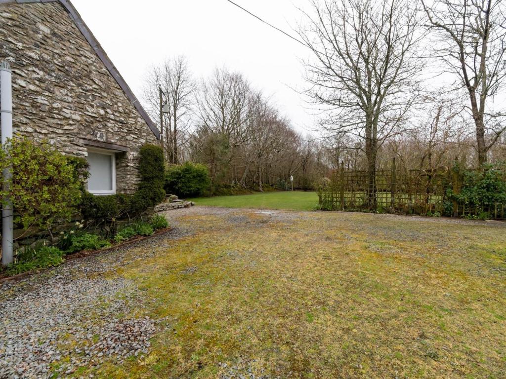 an empty yard next to a brick house at Secluded Holiday Home in Ceredigion with Garden in Pennant