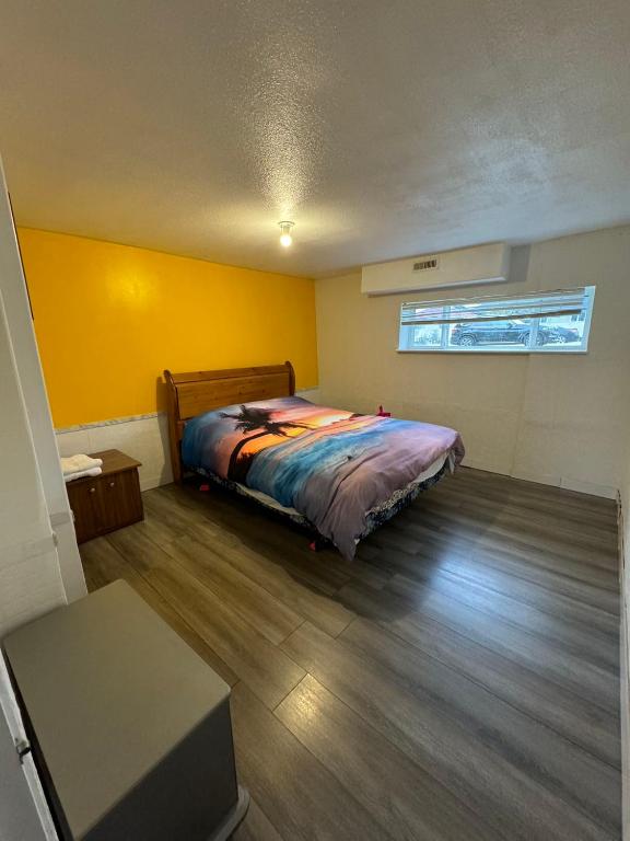 a bedroom with a bed and a yellow wall at Surrey central in Surrey