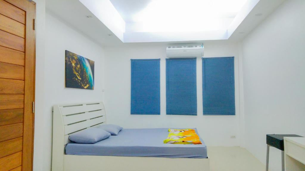 a bedroom with a bed with blue pillows at Studio in townhouse with private bath room and kitchenette in Amphoe Phra Khanong