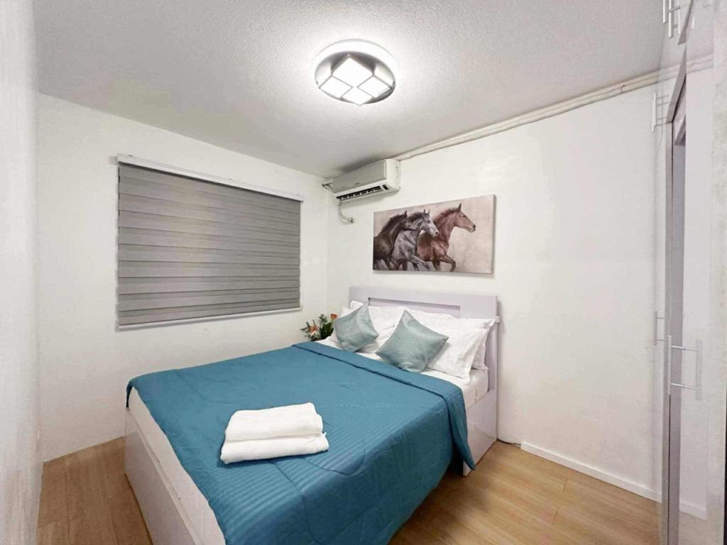 Ένα ή περισσότερα κρεβάτια σε δωμάτιο στο 2BR Condo with Free Pool and Wifi beside SM Ecoland