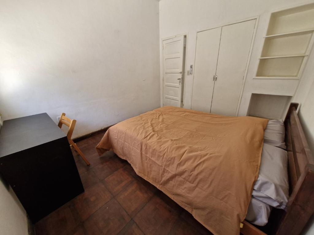 Un dormitorio pequeño con una cama y un escritorio. en Habitación de Casa en Av San Martin 422, en Santa Rosa