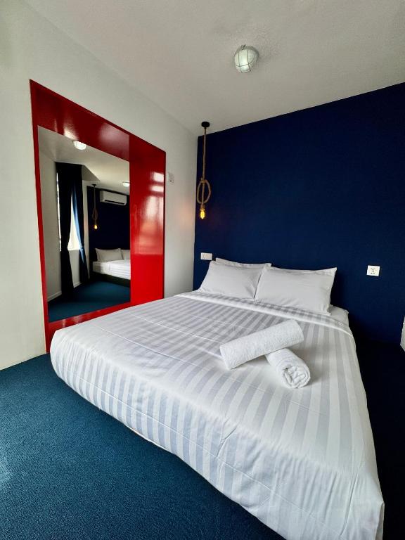 a bedroom with a large white bed with a blue wall at The Harbour by Moonknight in George Town