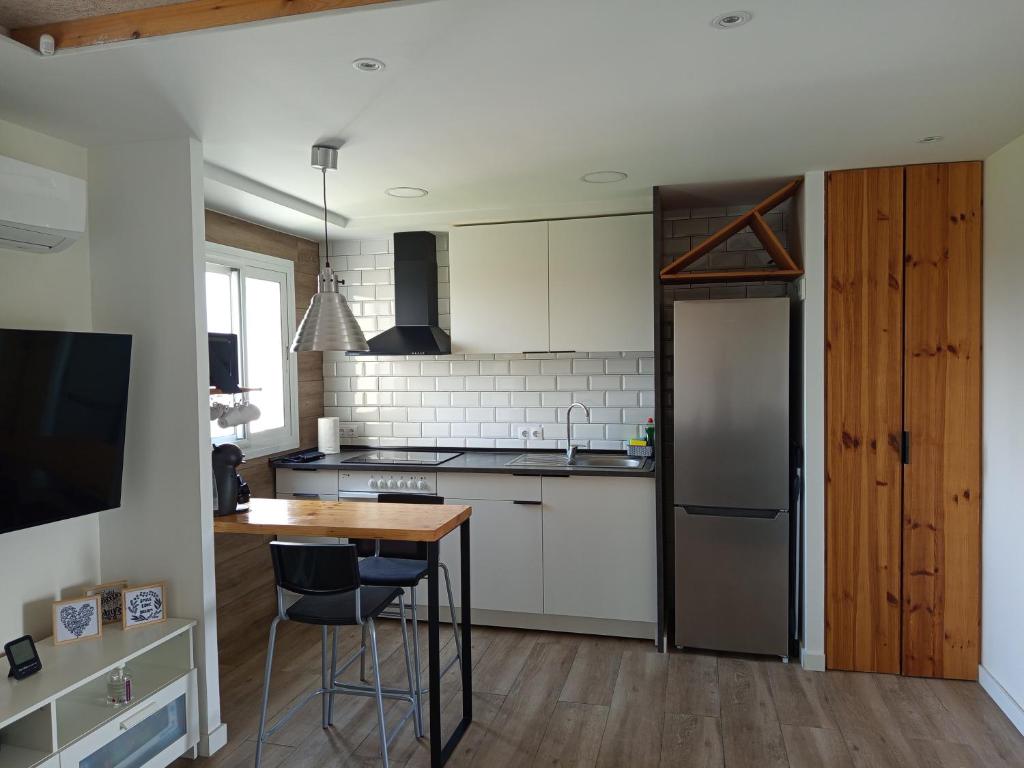 een keuken met een houten tafel en een koelkast bij Cambrils Bahía in Cambrils