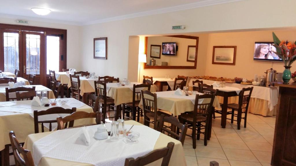 a dining room with tables and chairs with white table cloth at PHILIPPOS Hotel Apartments in Nikiana