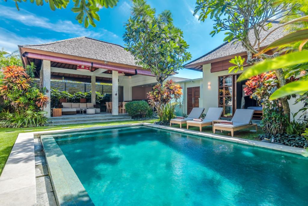 a swimming pool in front of a villa at Villa Essence in Seminyak