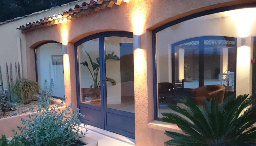 a house with large glass doors with lights on it at Hôtel les Bouis - Vue mer in Saint-Tropez