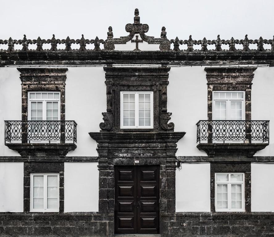 un vecchio edificio con tre finestre e una porta di Casa do Campo de São Francisco a Ponta Delgada