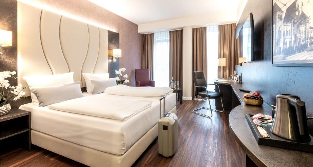 a hotel room with a bed and a desk at PLAZA Premium Berlin Kurfürstendamm in Berlin