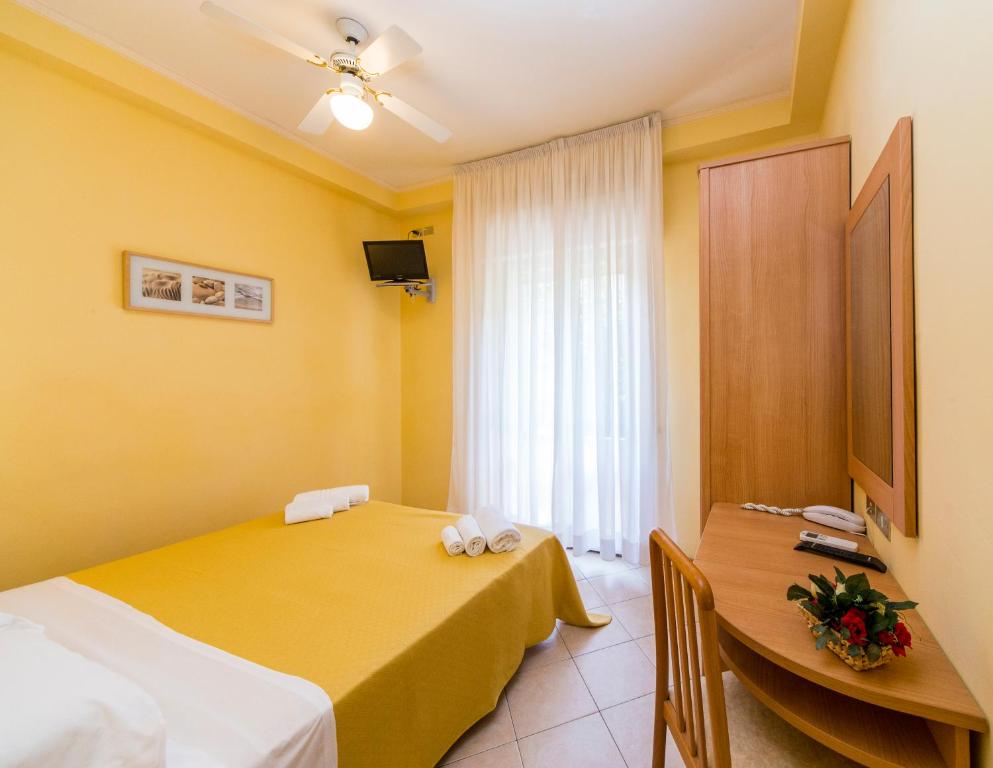 a hotel room with two beds and a table at Hotel Rita in Riccione