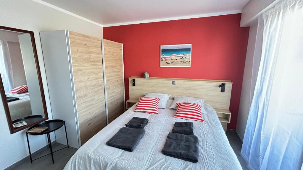 - une chambre dotée d'un lit avec un mur rouge dans l'établissement 1 Chambre dans appartement neuf, terrasse sud, meublé contemporain, parking, à Aix-les-Bains