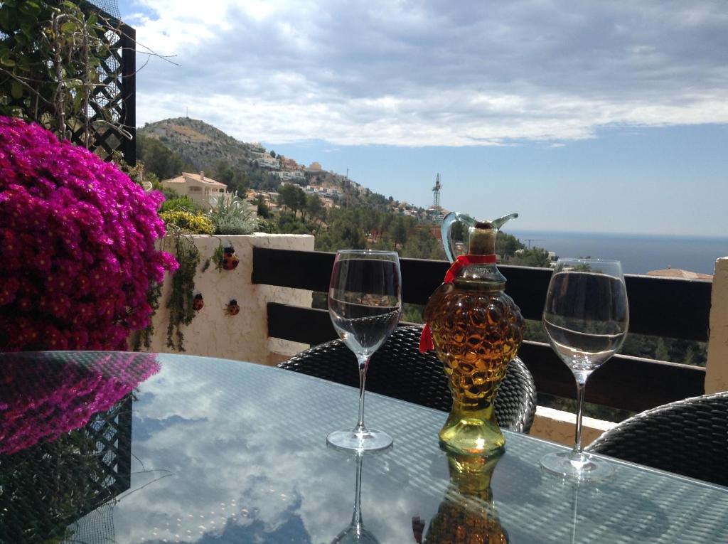 three wine glasses on a table with a view of the ocean at Olivos Holiday Home in Altea