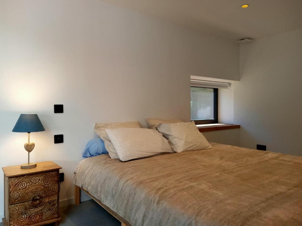 a bedroom with a bed and a lamp on a night stand at Superbe grange rénovée in Saint-Sulpice-le-Guérétois