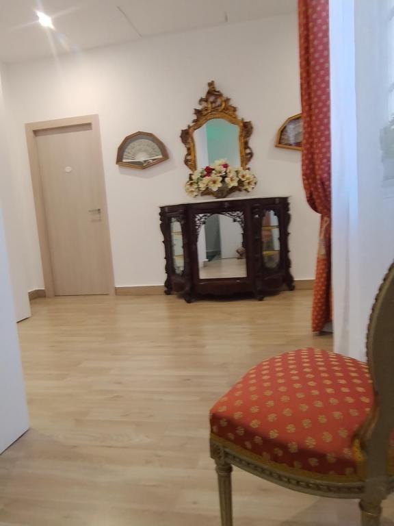 Una sala de estar con una silla y un espejo. en LE CAMERE DI VIA MECCIO, en Palermo