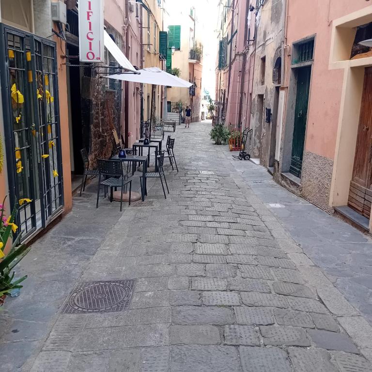 an alley with tables and chairs and an umbrella at Casa Milanesi in Monterosso al Mare
