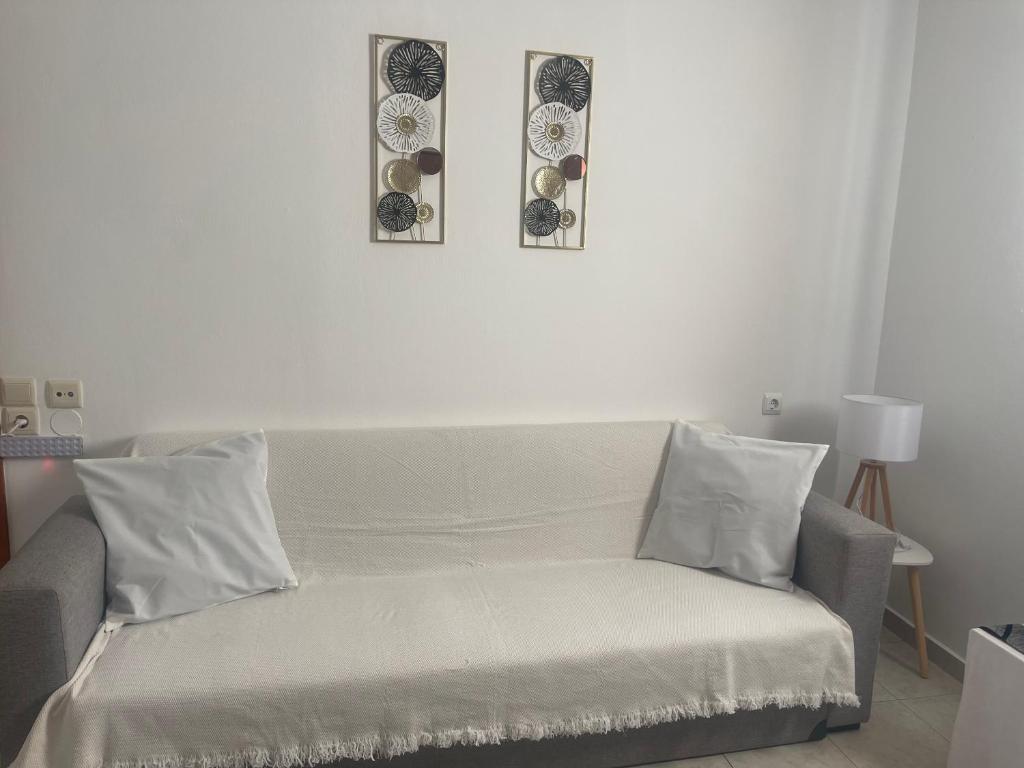 salon z kanapą i 2 zdjęciami na ścianie w obiekcie Heaven Studios & Apartments w mieście Stalida