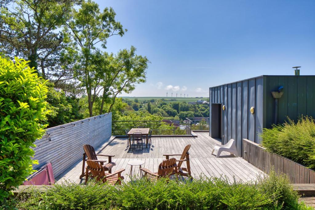 villa California - Villa d'exception avec vue mer panoramique - Veules-les-Roses في فول-لي-روز: فناء مع كراسي وطاولة على السطح