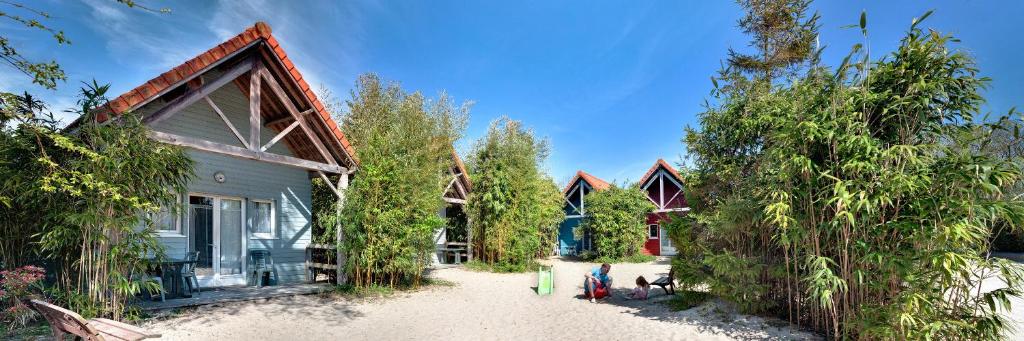 dom na plaży z drzewami przed nim w obiekcie Naturotel w mieście Fort-Mahon-Plage