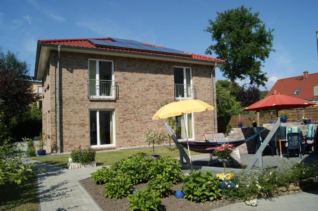 ein Haus mit einem gelben Regenschirm, einem Tisch und Stühlen in der Unterkunft Familie Schwantes in Buxtehude