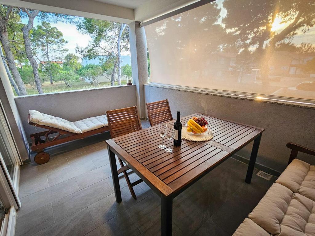 a table and chairs in a room with a large window at Apartman TIA in Vir