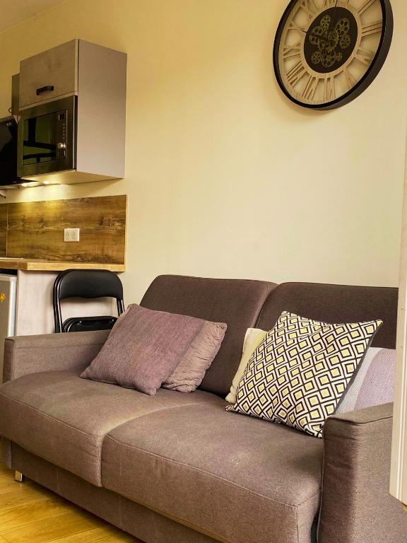 - un canapé dans le salon doté d'une horloge murale dans l'établissement Lyon Standing Historic City Apartment, à Lyon
