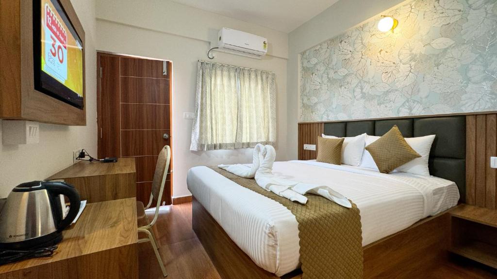 a hotel room with a bed and a tv at Dream Inn in Bangalore