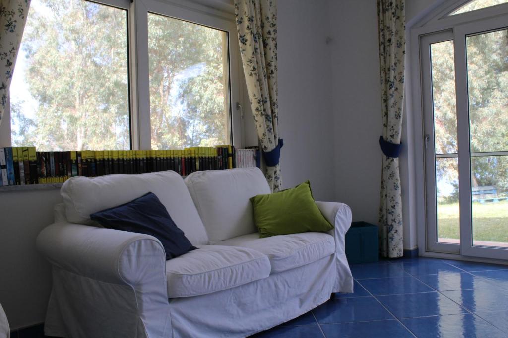 a white couch in a living room with windows at Agriturismo 'A Lanterna in Marina di Monasterace
